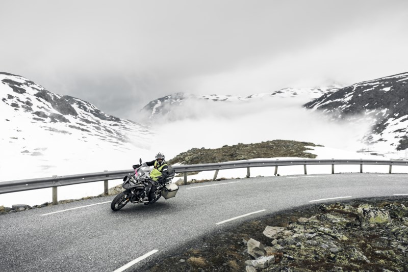 Mann pa motorsykkel i fjellandskap